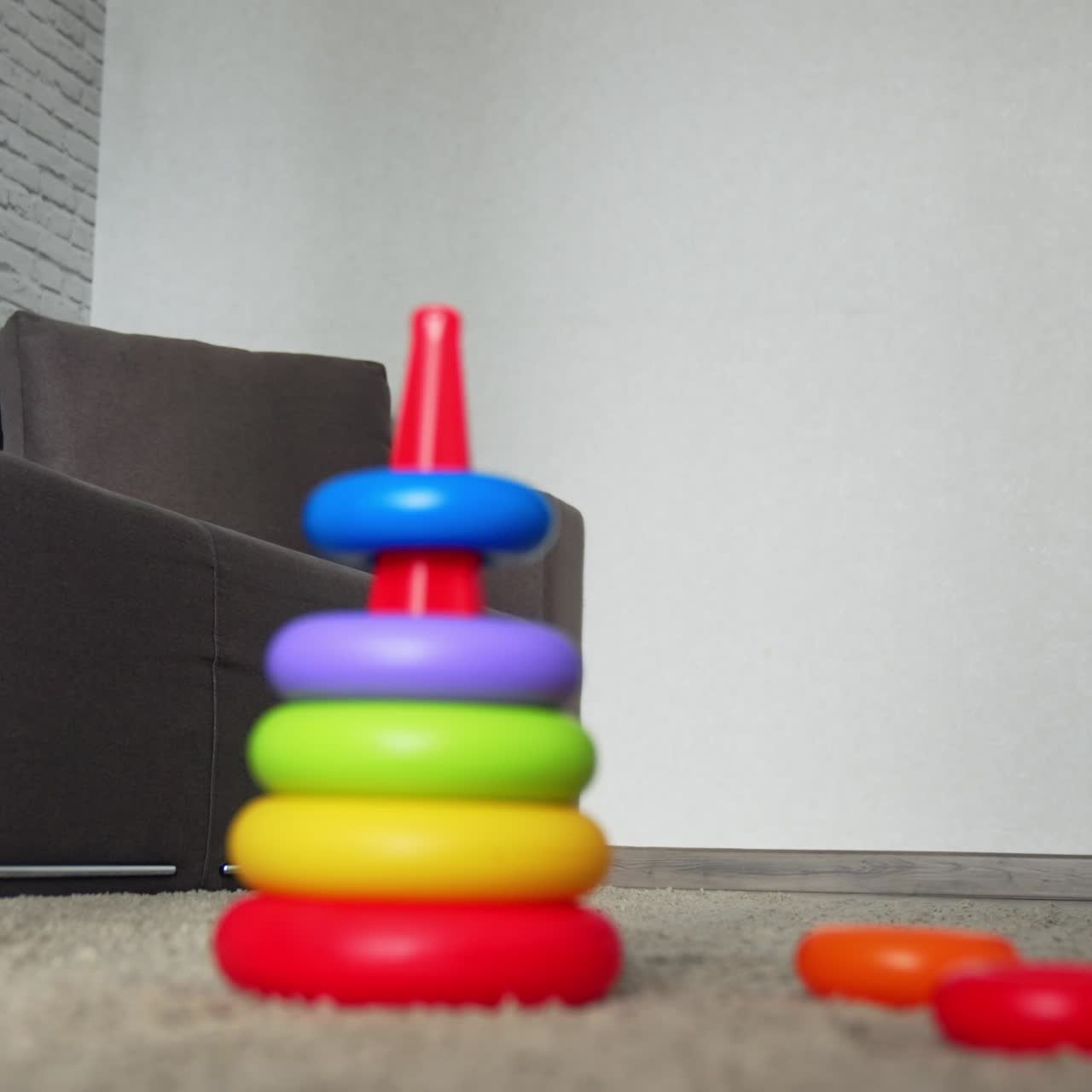 Blank kind met een pet zit bij de speelgoedpiramide. Lachend kind rent eropaf om het licht aan te doen. Lage hoek