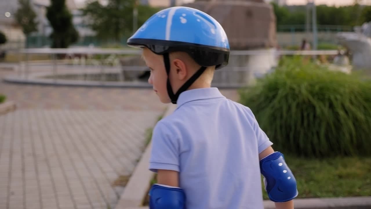 A little boy in a blue helmet rides a gyro scooter in a circle in the Park.