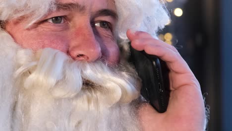 portrait of santa claus talking on smartphone close up portrait of santa claus talking on smartphone santa communicates with children on the phone the christmas character talked on a mobile phone on christmas eve