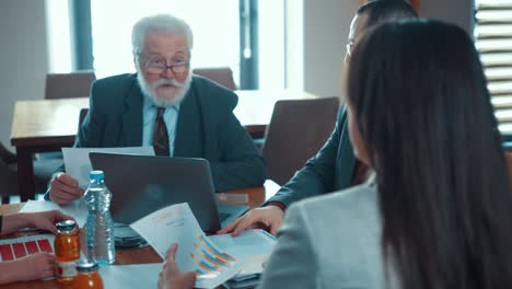 business team in action at a business meeting in a restaurant. four business people in a working action at a meeting, communication, planning, solving financial problems