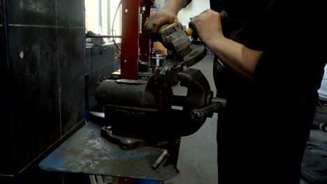 closeup of worker using a grinder cuts metal in a workshop