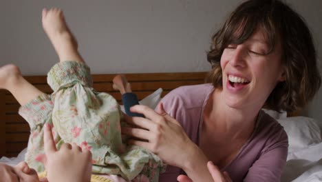 mujer caucásica con su bebé en casa en el dormitorio