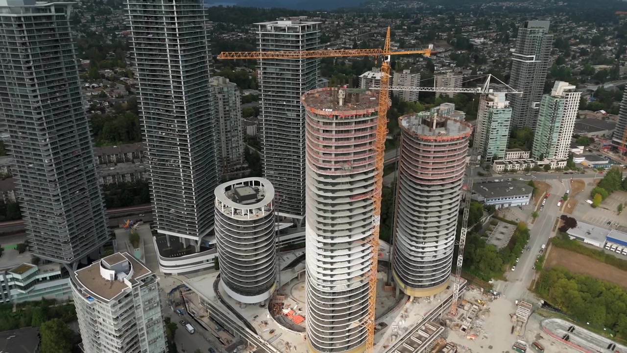 Torres residenciales de gran altura en construcción con grúa en Burnaby, Columbia Británica, Canadá. - toma aérea