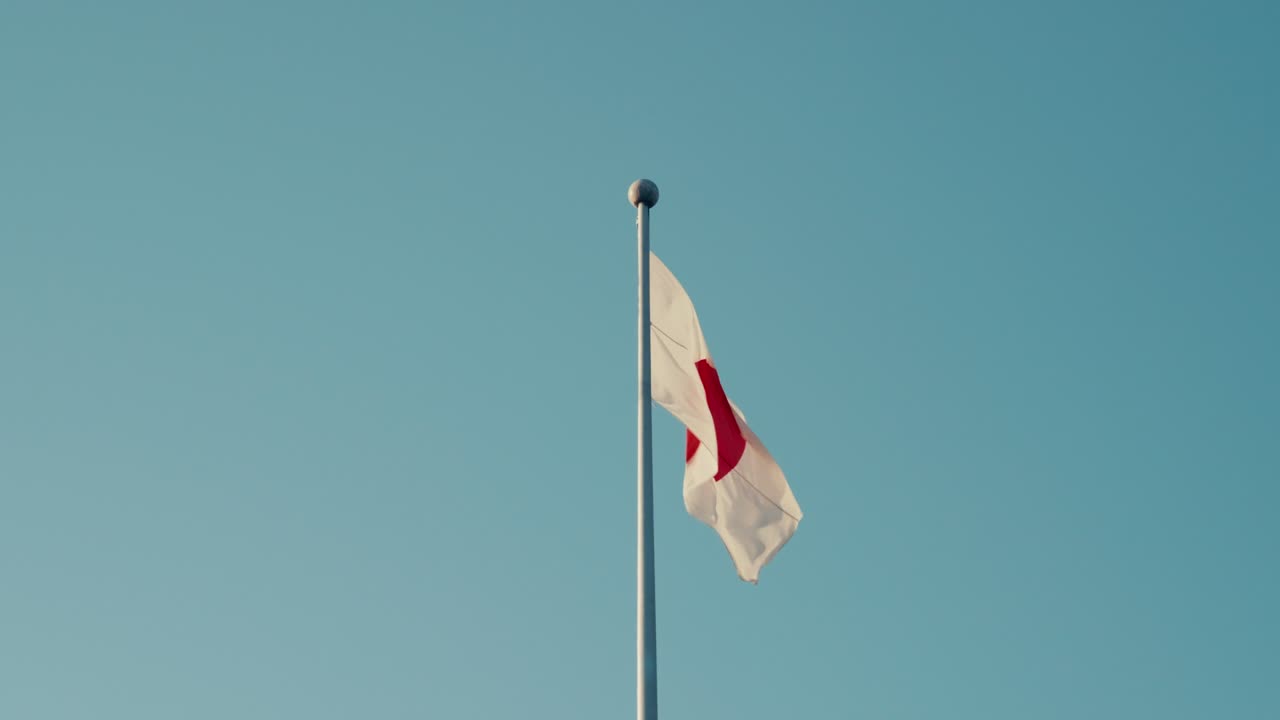 Flag Rising in Daylight — Japan’s national flag sways under daylight, symbolizing freedom, culture, and a warm welcome to travelers.