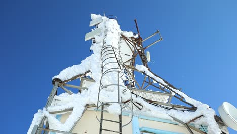 gran antena cubierta de nieve y hielo en la cima de la montaña, de abajo hacia arriba