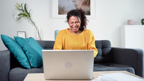 video sobre una mujer negra celebrando la victoria usando una computadora portátil