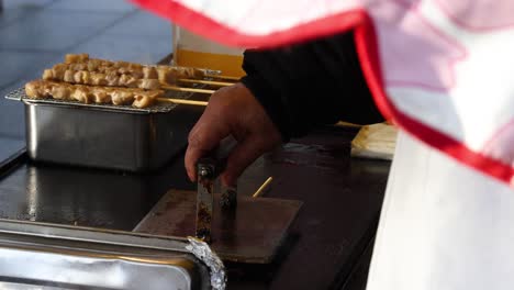 sequential preparation of skewered snacks on a grill