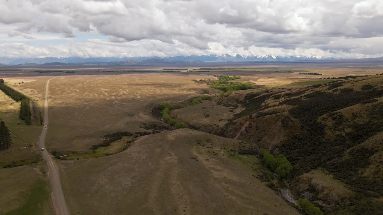 뉴질랜드 남부 산의 사막 도로를 달리는 자동차