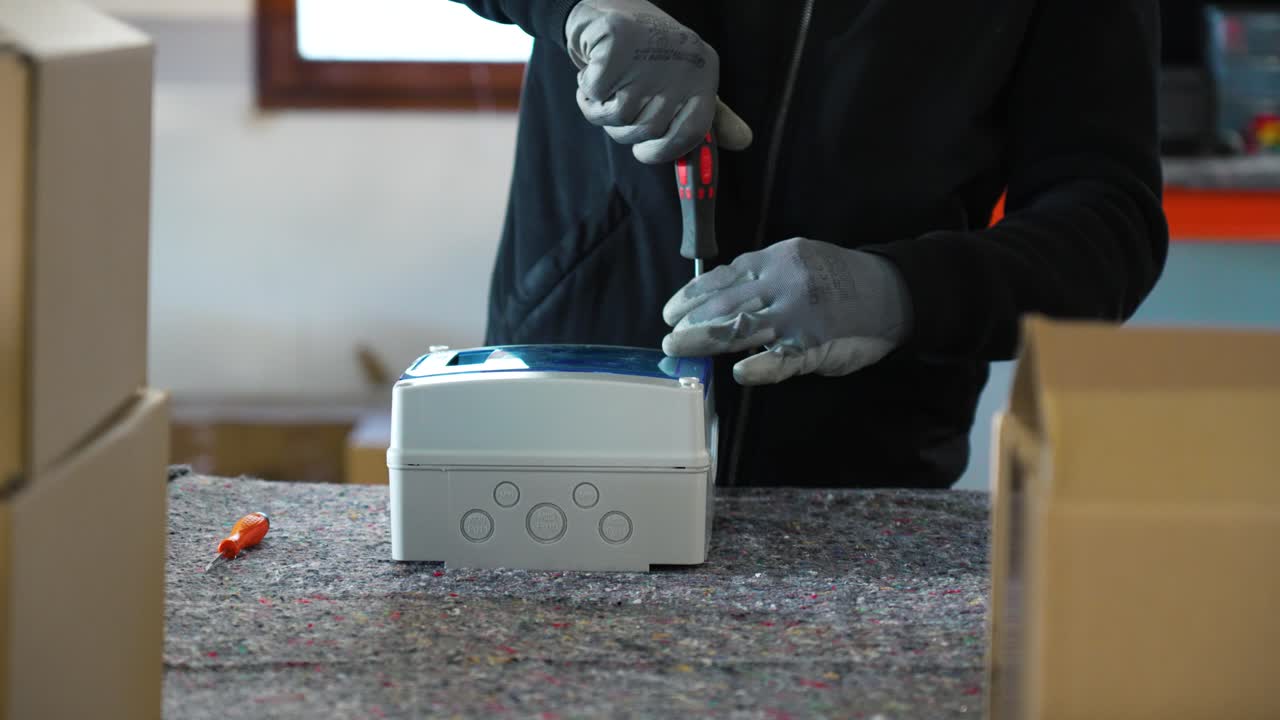 electricista cerrando una caja con un destornillador