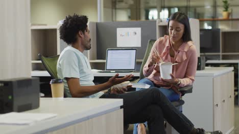 video of happy diverse businesswoman and businessman eating and talking in office