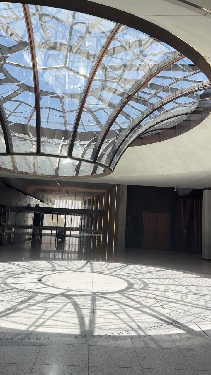 Uma panorâmica lenta da câmera captura a luz do sol entrando por um teto de vidro em cúpula sobre pisos de pedra