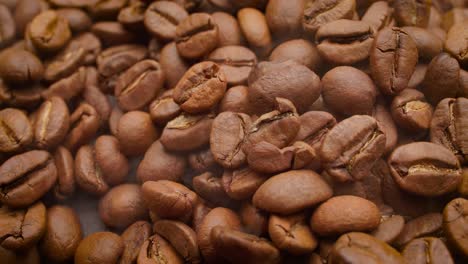 Close-up-of-seeds-of-coffee.-Fragrant-coffee-beans-are-roasted-smoke-comes-from-coffee-beans.