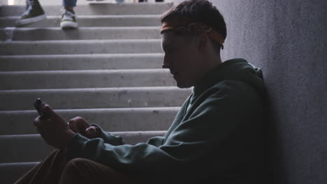 Young-man-using-smartphone-on-stairs