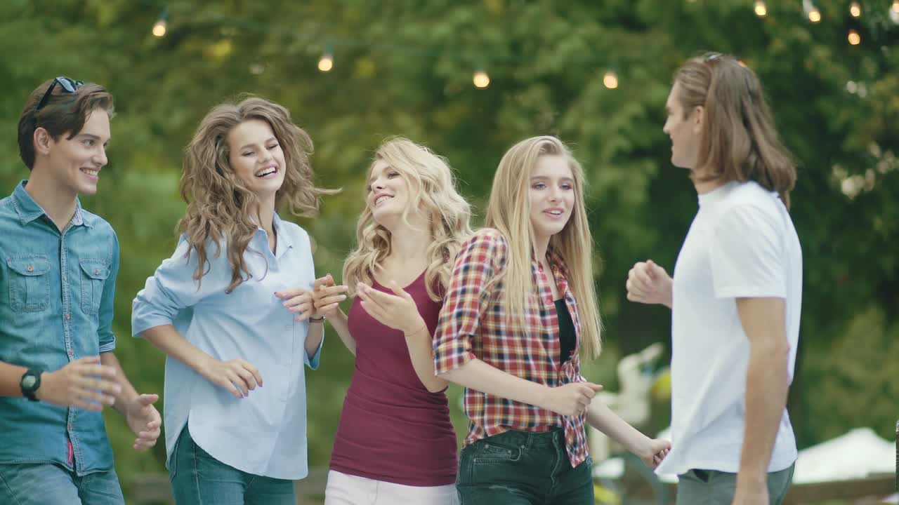 행복한 친구들이 춤을 추고, 재미를 느끼고, 야외 파티를 즐기고 있습니다.