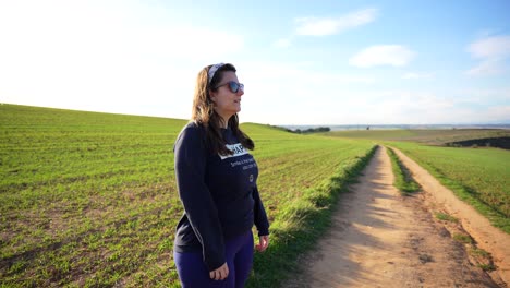mujer joven abriendo los brazos profundamente respirando aire fresco en el campo