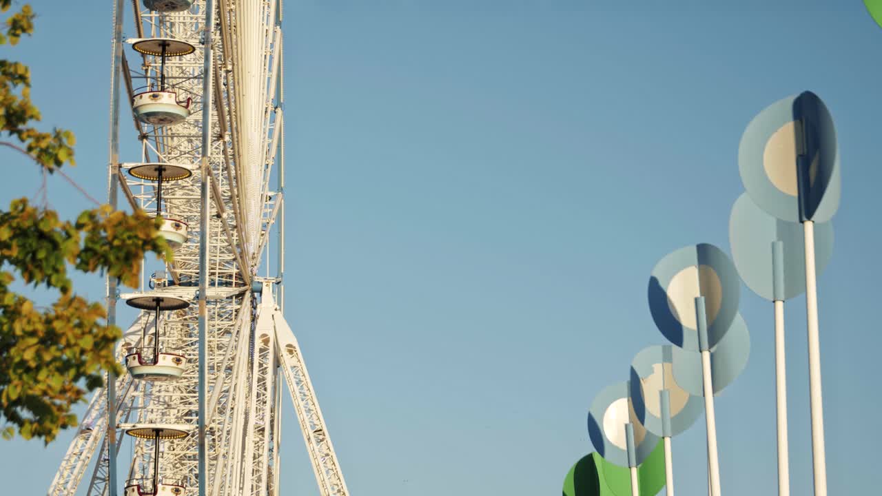 Static shot of white ferris wheel spinning with warm evening light and pastel sky at Sinksenfoor in Antwerp, Belgium