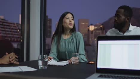 Video-of-asian-businesswoman-talking-to-diverse-colleagues-at-evening-office-meeting