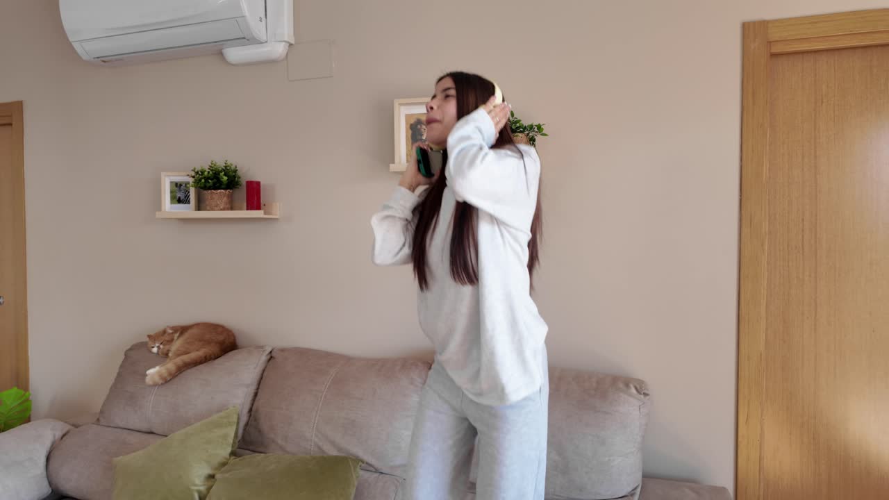 Woman dancing in living room with cat