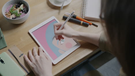 Woman Drawing on a Tablet in a Cafe