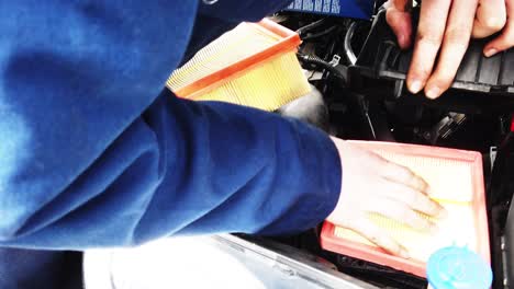 a workshop technician removing the vehicle air filter