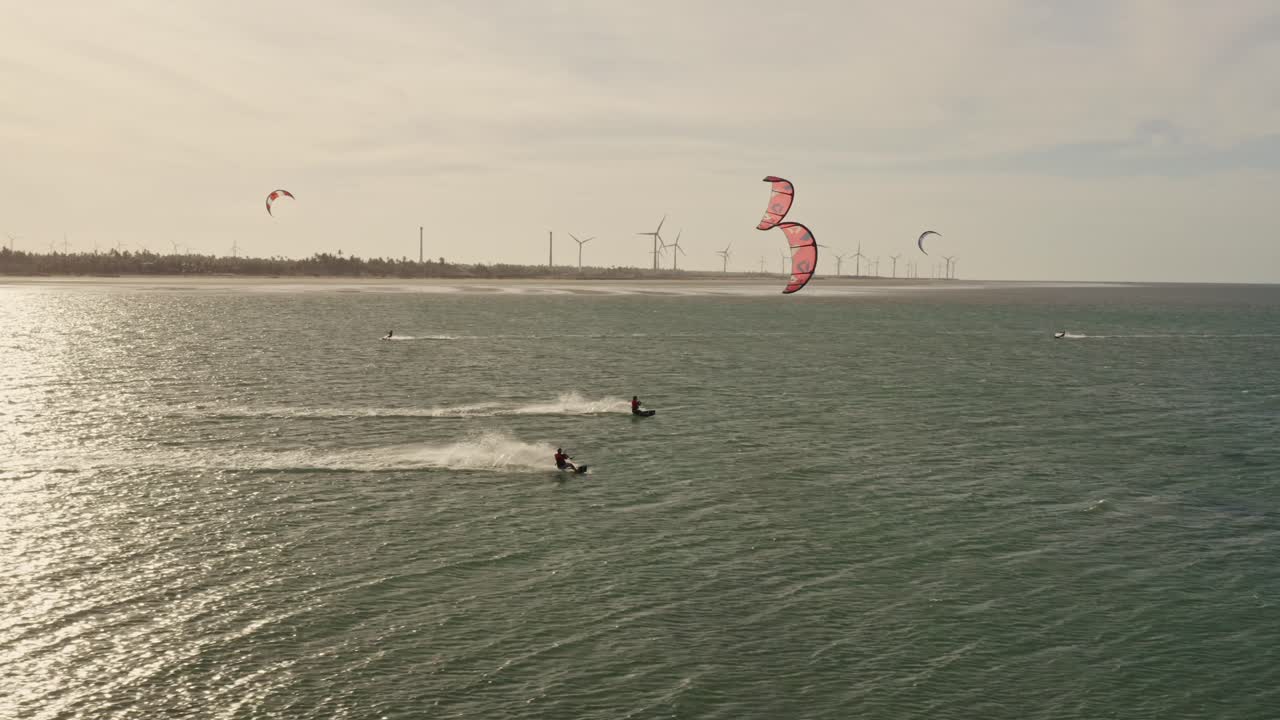 dos kitesurfistas a alta velocidad a través de la ondulación del océano al atardecer