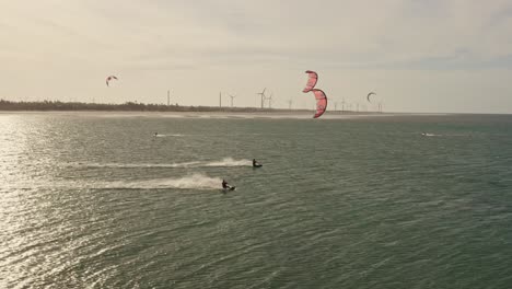 Two-kite-surfers-in-high-speed-through-ocean-ripple-in-sunset