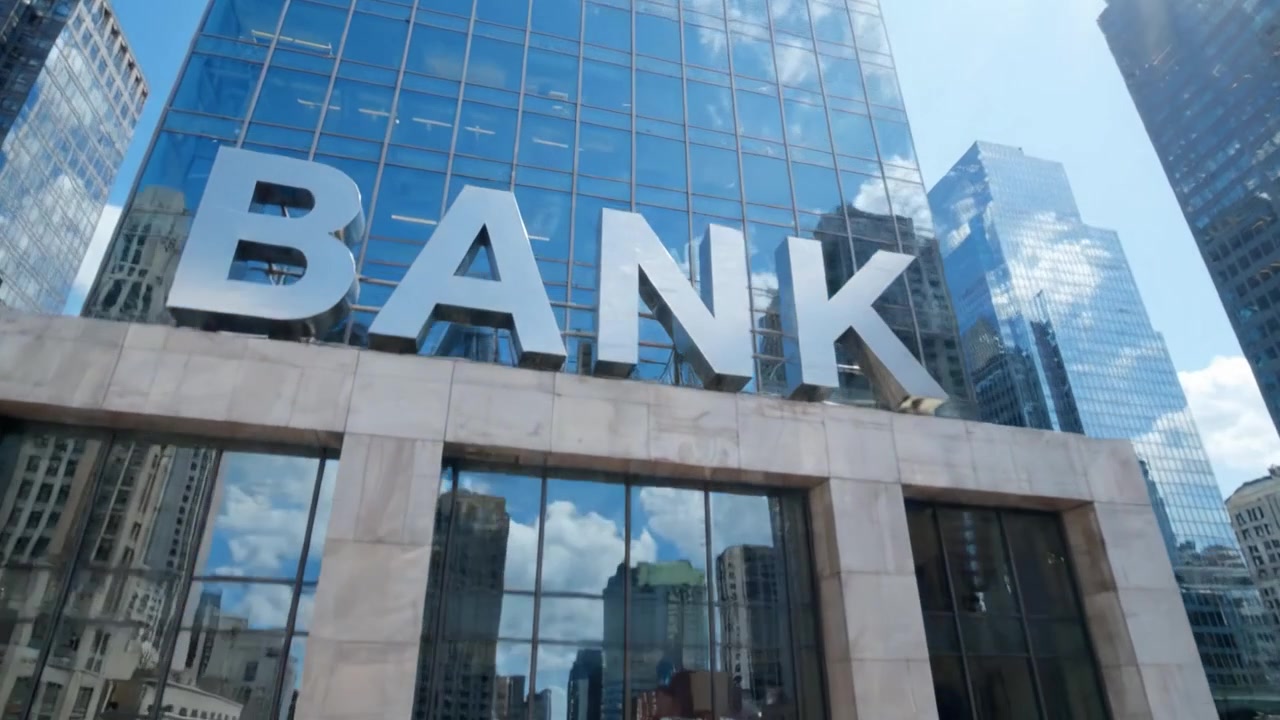 Um Edifício Bancário Moderno Refletindo a Vida Urbana: Uma Coleção de Pessoas Passando e a Placa Proeminente do Banco em uma Paisagem Urbana Agitada