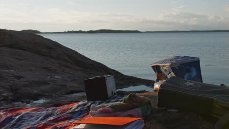 Calm-and-relaxing-vacation-concept-with-plaid-on-lake-coast,-static-view