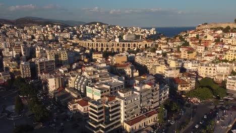 Aerial-view-of-beautiful-ancient-Roman-aqueduct-next-to-the-ocean-at-sunset-in-Kavala,-Greece