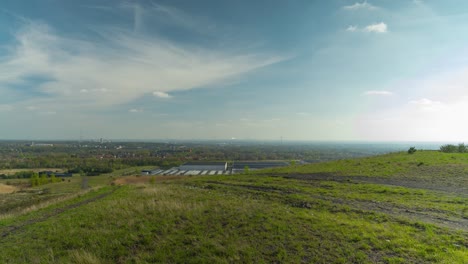 Kleines-Industrielles-Stadtbild-Mit-Windkraftanlagen-Vom-Bergbauhaufen-An-Lebhaftem-Sonnentag,-Statische-Zeitrafferansicht