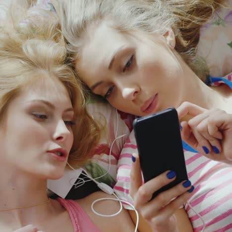 two young women relaxing at home listening to music 1