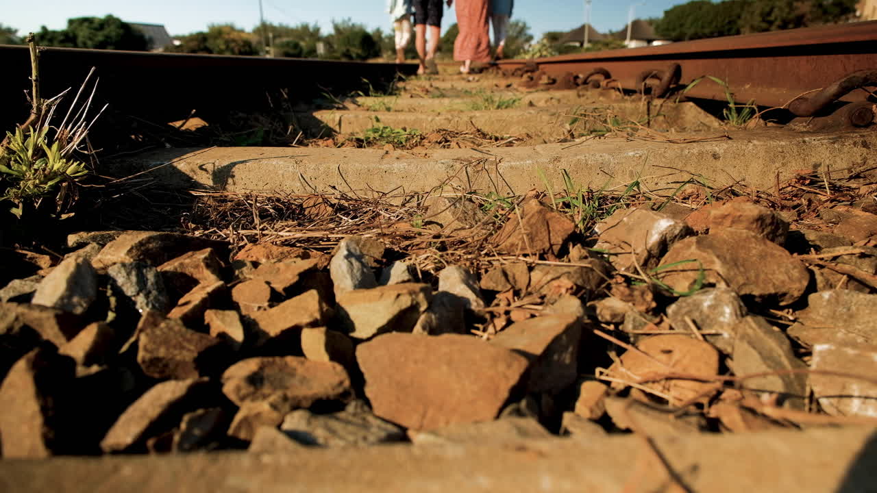 los padres ayudan a los gemelos a caminar en las vías del tren, tiempo de calidad en familia