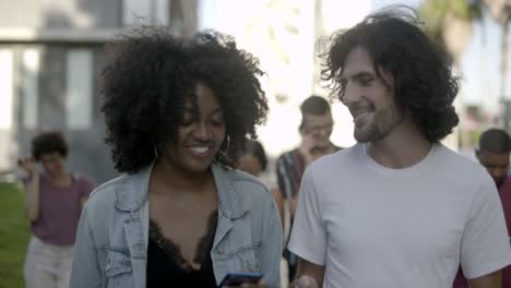 Smiling-young-people-talking-while-walking-in-park.