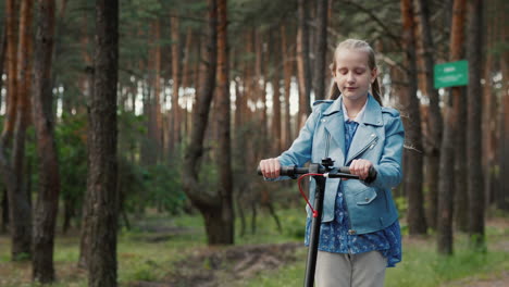 side view of a joyful child riding an electric scooter on the road in the park