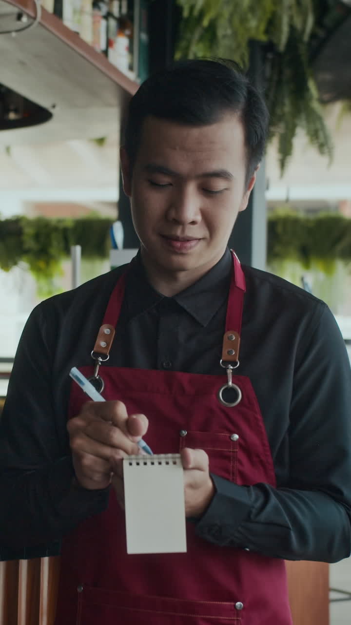 Waiter Making Notes while Listening to Client Ordering in Cafe