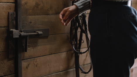 girl opening a door in a stable