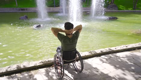 un joven feliz y relajado sentado en su silla de ruedas.