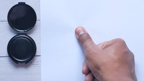 putting fingerprints on a paper close up