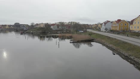 una vista escénica de pequeños puentes de madera sobre aguas tranquilas, un grupo de pájaros, un saunaraft y la hermosa isla ekholmen de karlskrona, suecia en el fondo