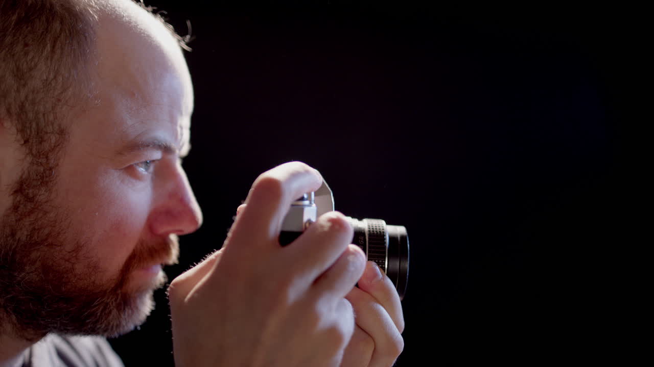 cámara lenta retroiluminada - un fotógrafo toma una foto con una cámara slr vintage