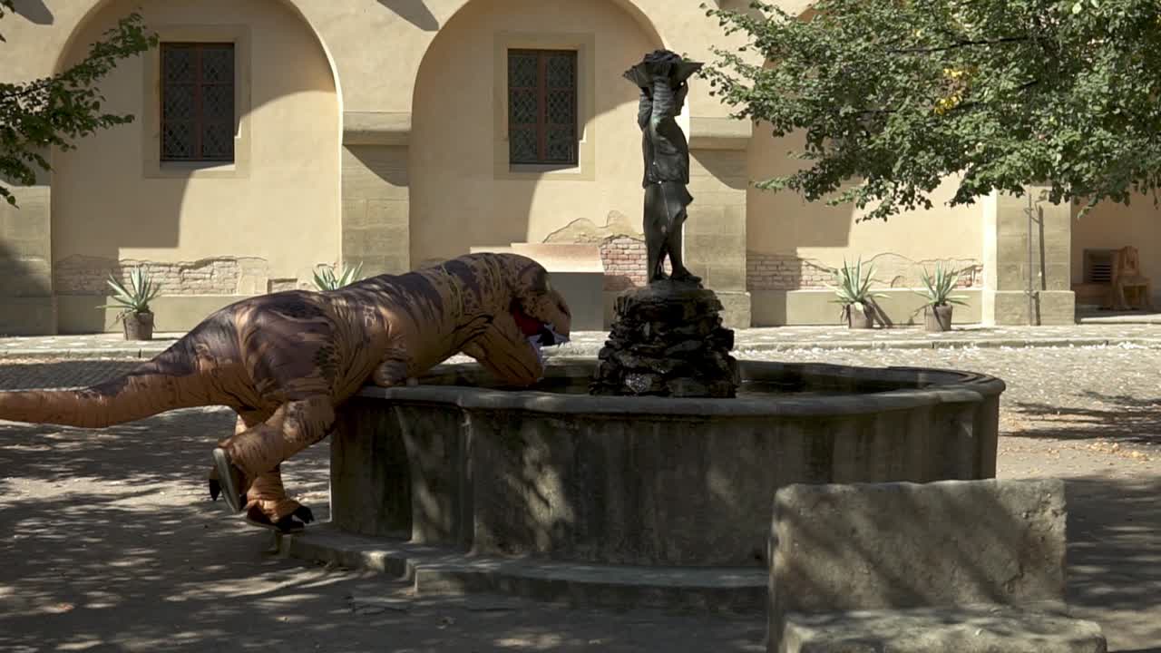 중간에 광부가 서있는 중세 우물에서 풍선 티라노사우루스 렉스 식수