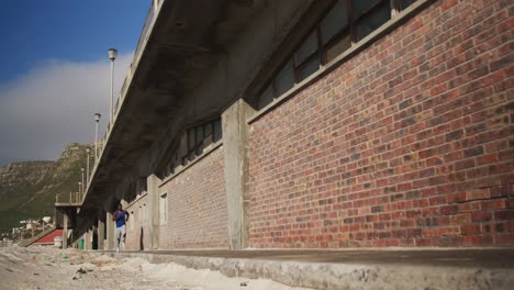 hombre afroamericano corriendo por el pavimento, haciendo ejercicio al aire libre en un día soleado