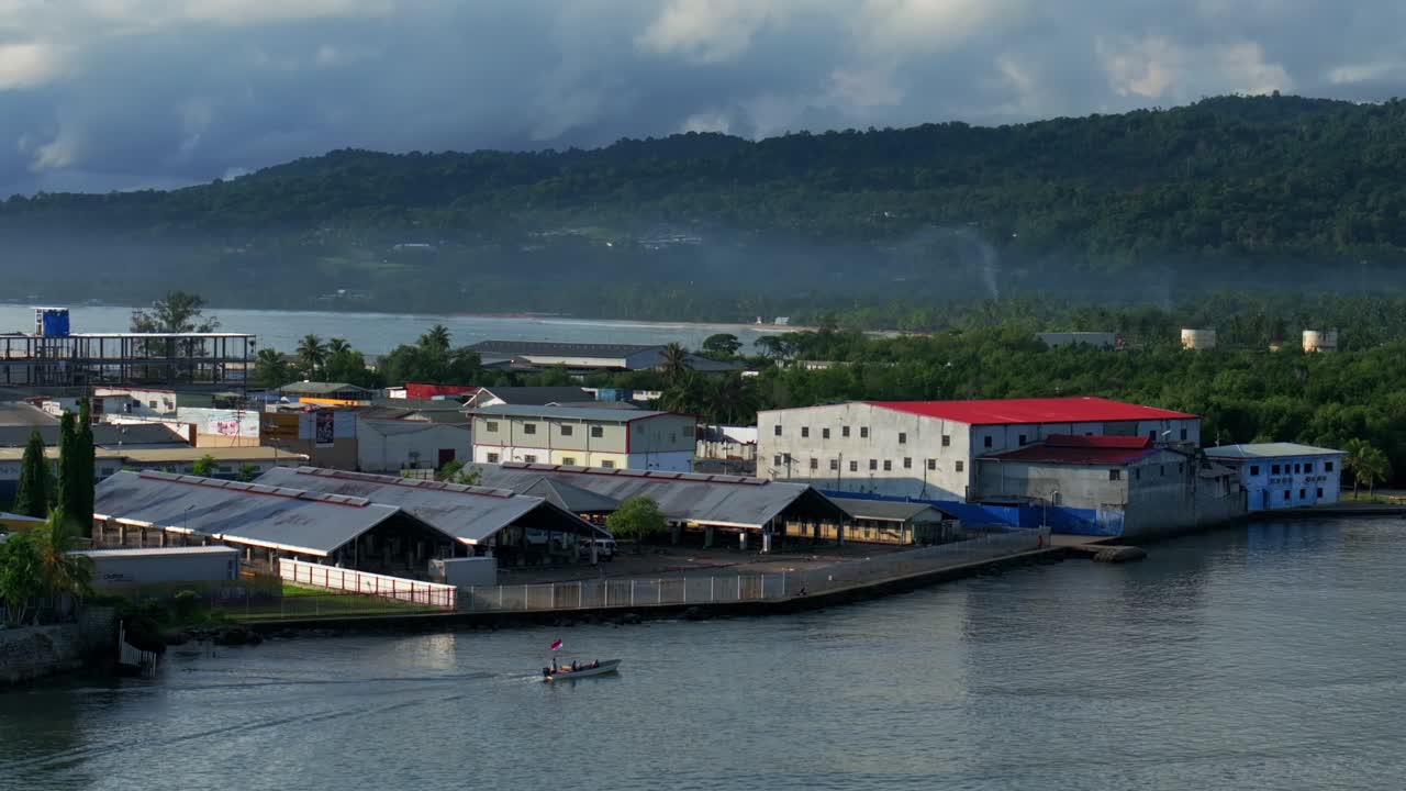 Canoe Boating Dogreto Bay Wewak Sundaun fish Market Wewak Hill buildings cars traffic Boram road Papua New Guinea aerial drone downtown coastal town city center early sunny morning blue sky static