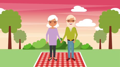 una pareja de ancianos de pie sobre una manta en el paisaje del parque