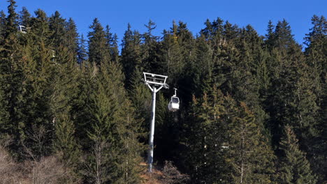 time lapse of a bubble ski lift passing through a gap in a forest in the french alps