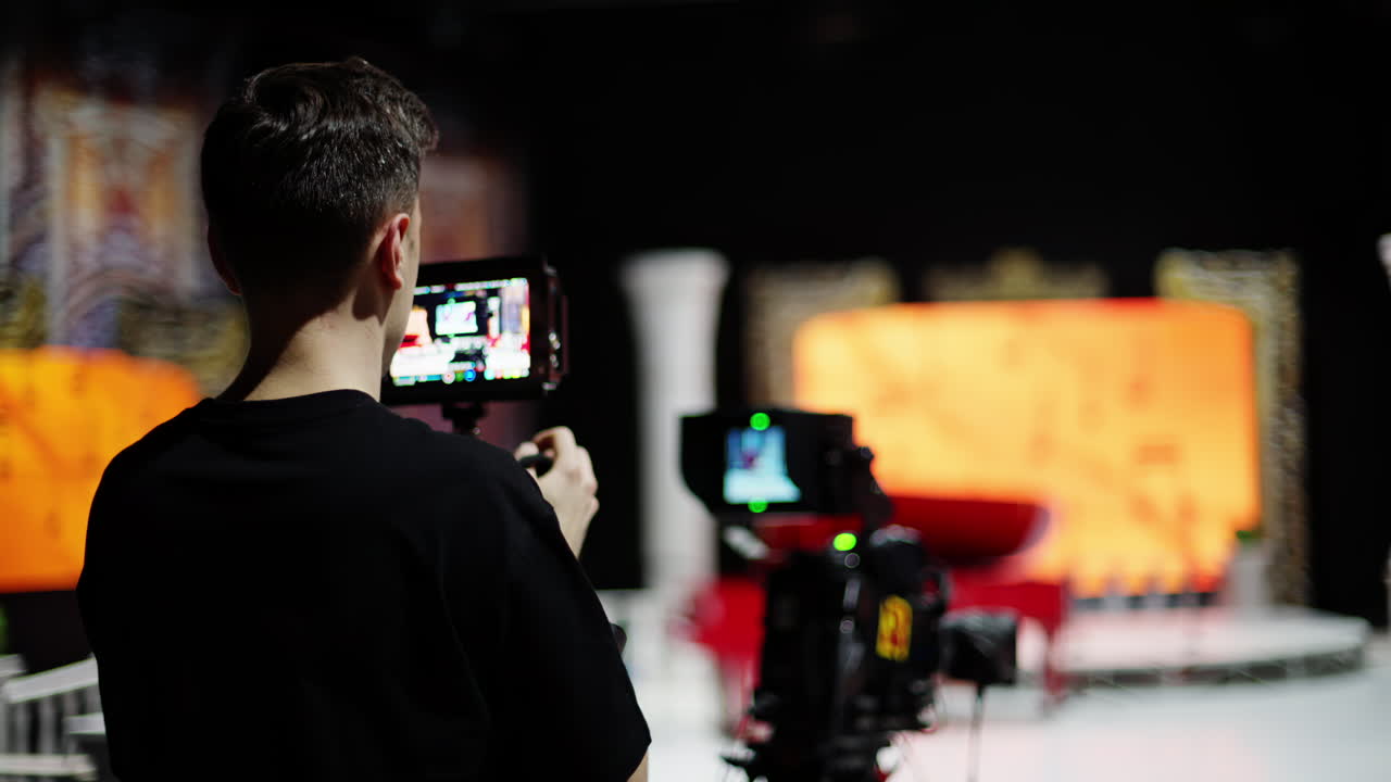 Man filming with professional camera on the backstage of a TV set