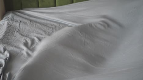 unmade bed with gray sheets