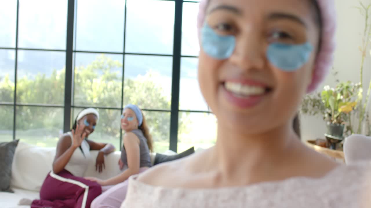 African American woman stepping after friends wave on sofa, talking to camera with blue patches