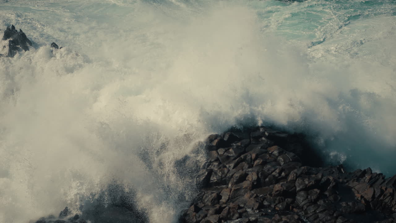 강력한 파도가 바위가 있는 해안에 부히고