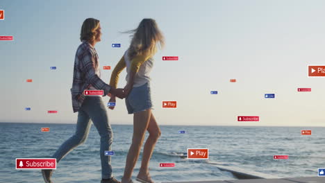 Social-media-interaction-animation-over-couple-holding-hands-and-walking-by-sea